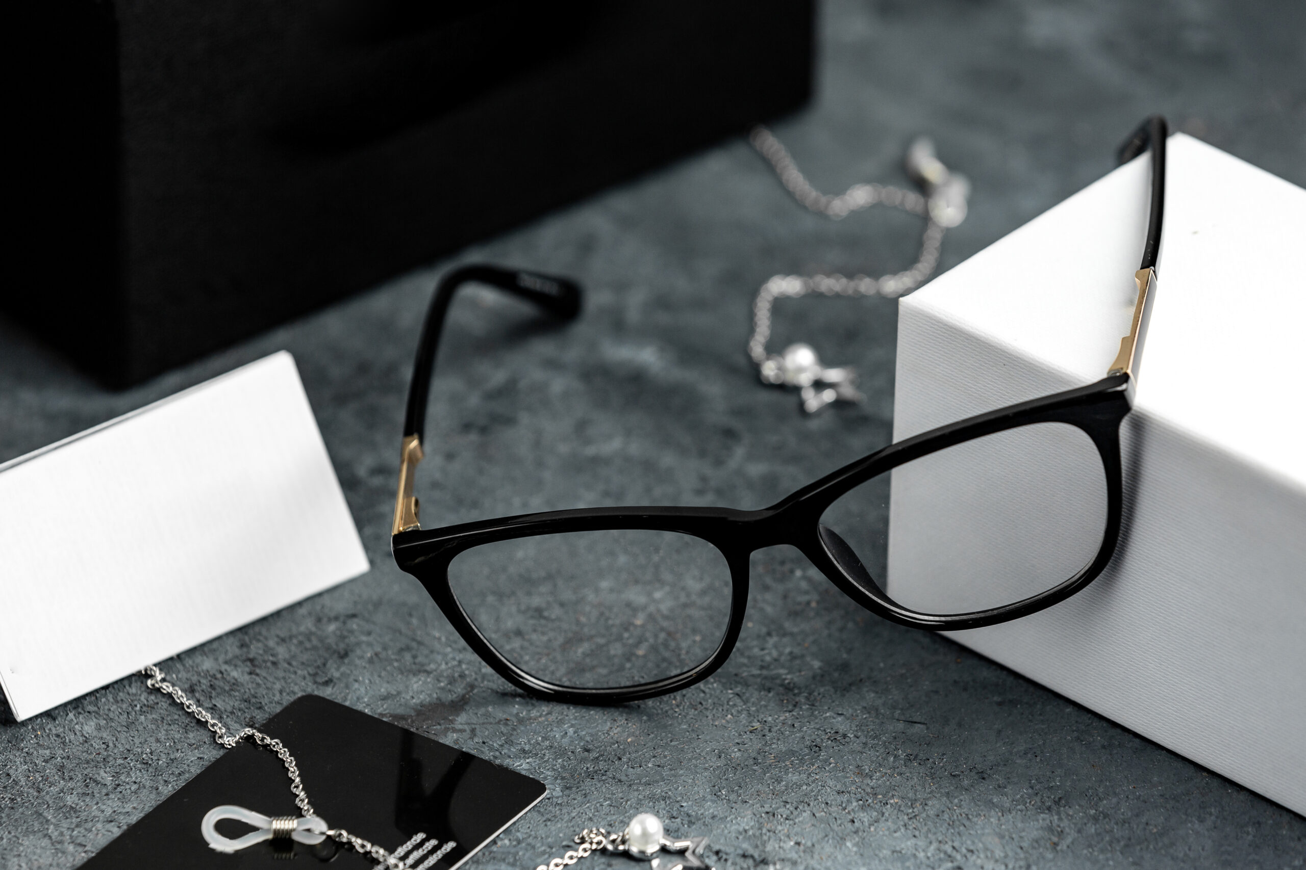 front-view-optical-sunglasses-grey-desk-with-silver-bracelets-isolated-sight-vision-eyes (1)